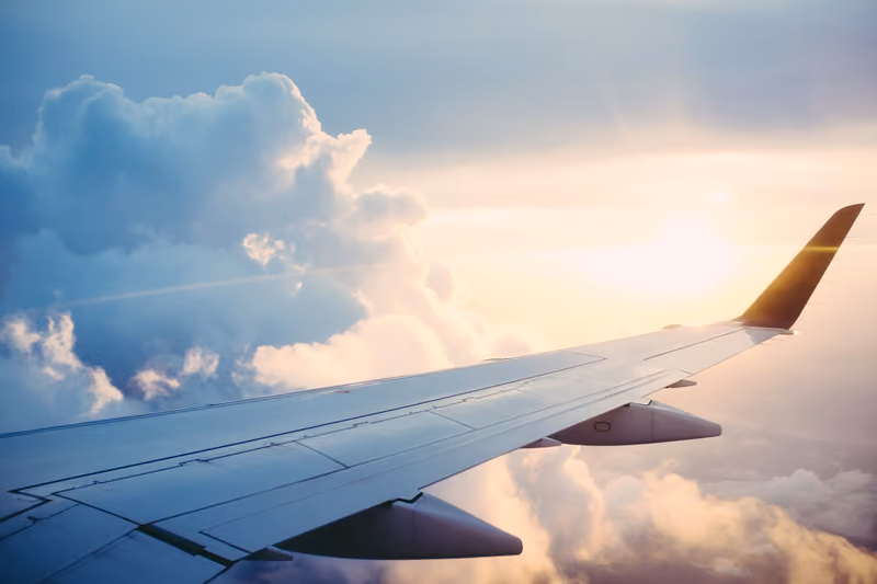Airplane wing above the clouds at sunrise